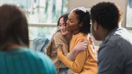 two teen girls hugging