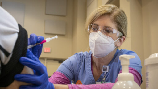 A nurse gives a patient a shot of the COVID-19 vaccine