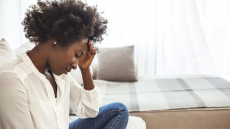 Woman sitting down with her head in hands