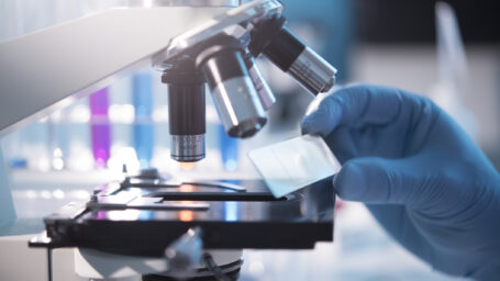 A scientist placing a slide under a microscope