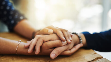 two people holding each other hands in support