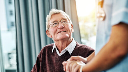 An older man showing appreciation to his nurse