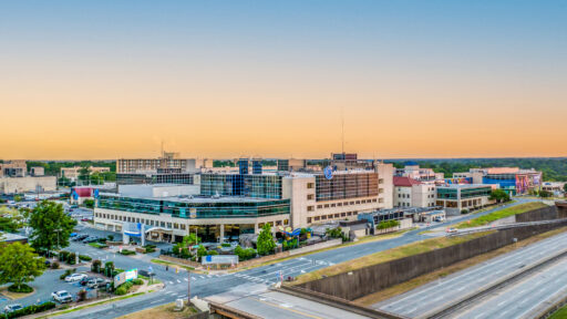 An aerial shot of Arkansas Children's Hospital, the sunset softening the sky in oranges and pinks.