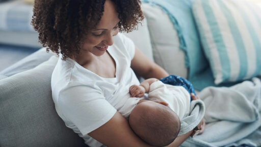 A Black mother breastfeeds her infant child