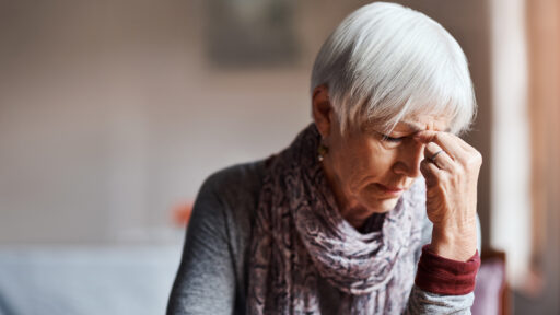 Shot of a senior woman experiencing a headache in a retirement home