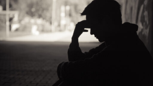 man sitting down with his head in his hands