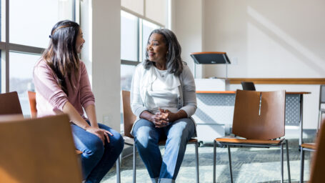two women sitting and talking together
