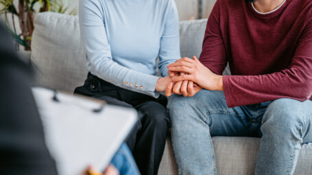 A couple holding hands while in the therapy.