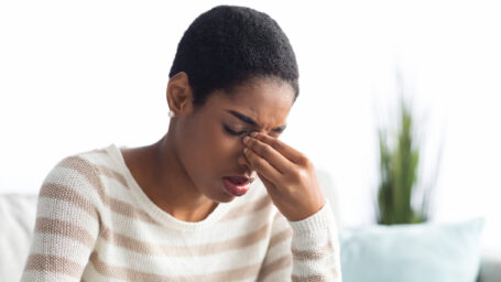 Sinusitis Concept. Sick Young Black Woman Touching Her Nose Bridge While Sitting On Couch At Home, African American Lady Feeling Unwell, Suffering From Rhinitis Or Seasonal Allergy, Free Space