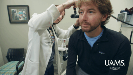 Physician at UAMS East examines the ear of a patient