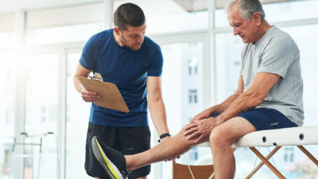Physical therapy consultation with senior patient.