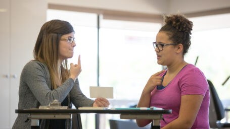 Female speech therapist helping a teenage patient inside of a clinic
