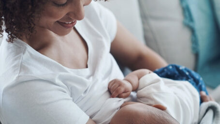 A Black mother breastfeeds her infant child