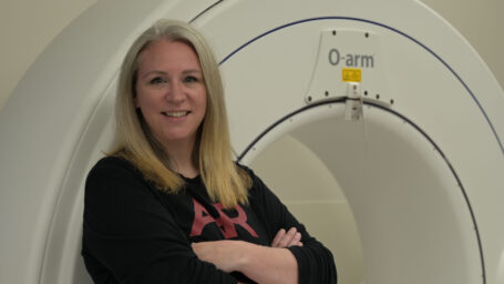 woman posing in front of a MRI machine