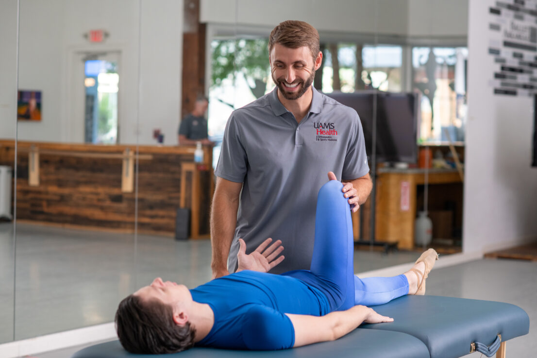 UAMS PT stretching a male ballerina