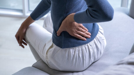 Young woman clutching her lower back