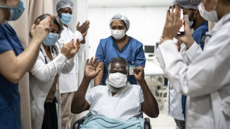 team of doctors and nurses cheering on a patient