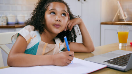 A young girl trying to do homework.