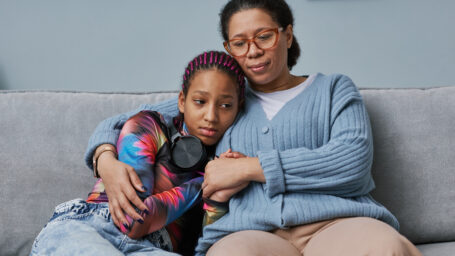 mom embracing teen daughter