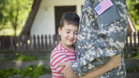 a little boy hugging his military dad